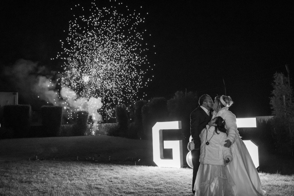 Novios bajo fuegos artificiales en blanco y negro