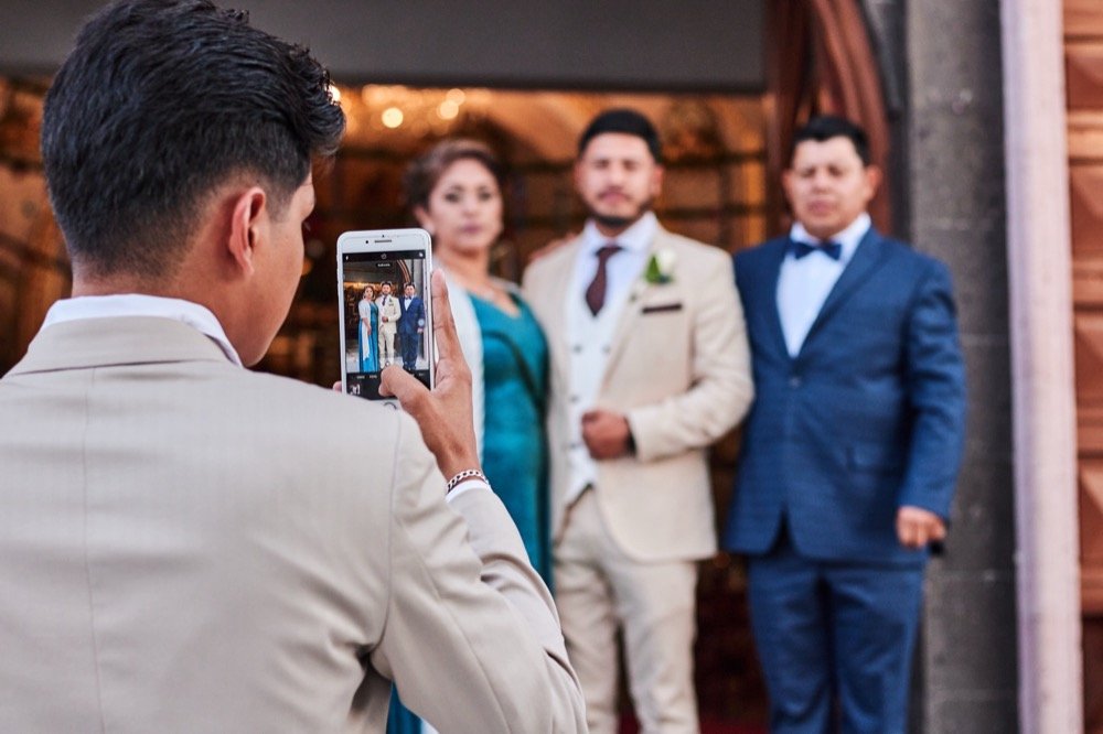 Invitado fotografiando a los novios con su celular