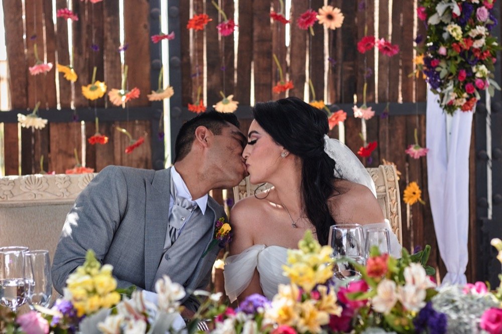 Novios besándose en la mesa de honor