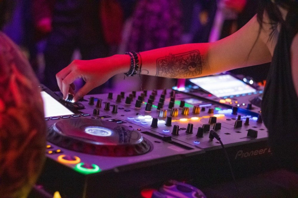 DJ mezclando en una consola iluminada