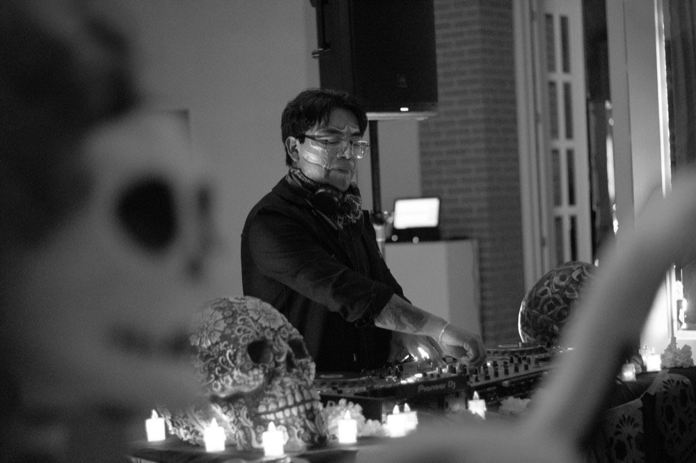 DJ en blanco y negro junto a una calavera