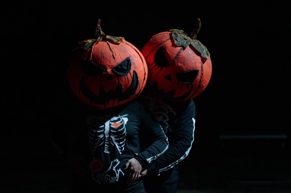 Pareja con cabezas de calabaza en sesión de Halloween