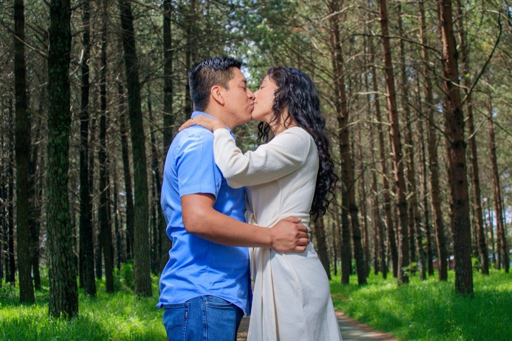 Pareja besándose en un bosque