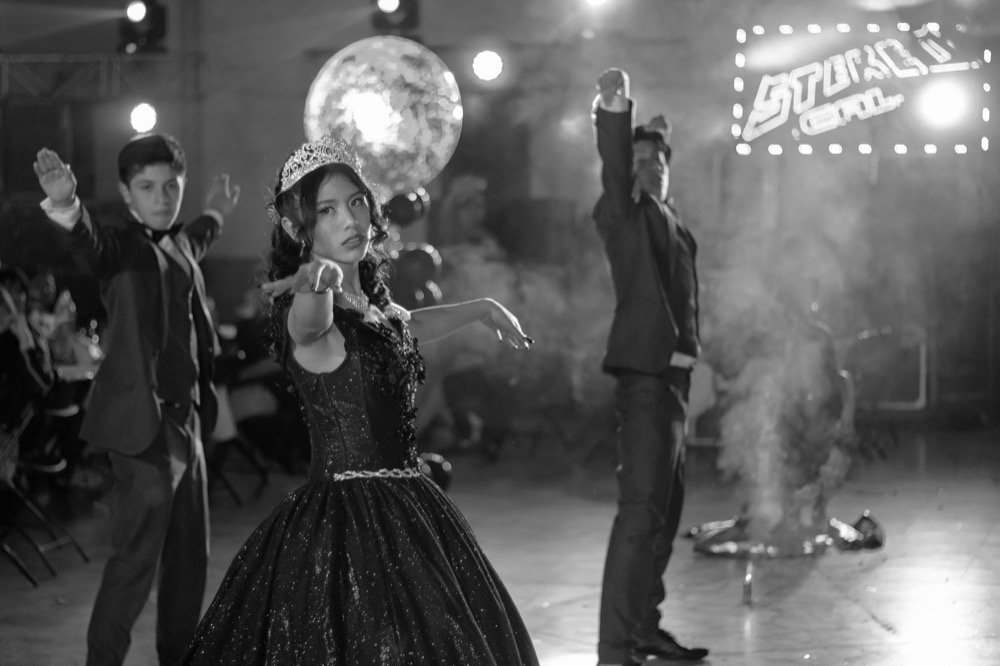 Quinceañera bailando en blanco y negro con chambelanes